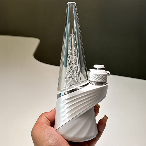 Frau hält einen Puffco Peak Pro 3DXL an der Silikonbasis hoch