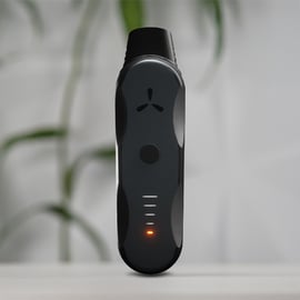 AirVape XS Go Kräuter-Vaporizer aufrecht auf weißer Fläche mit orange leuchtender LED.