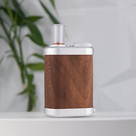 Tinymight 2 Vaporizer mit elegantem Holzgehäuse, Metallkonstruktion und Glasmundstück, vor einem schönen Hintergrund.