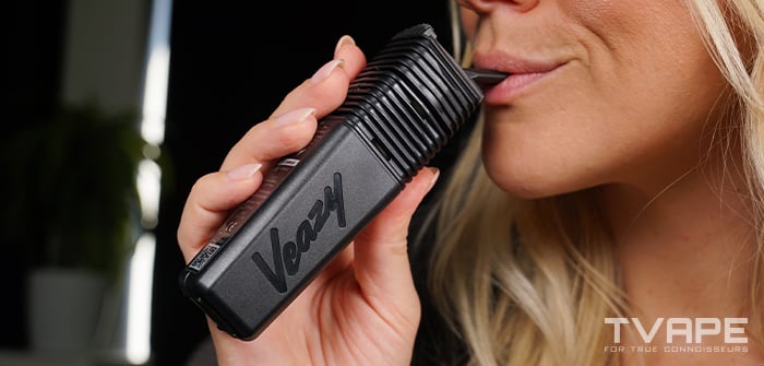 Eine Frau inhaliert aus dem Veazy Vaporizer von Storz und Bickel.