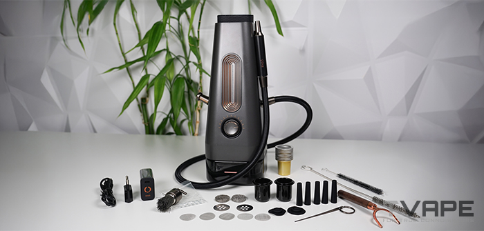 Das komplette AirVape Enso 2026-Set, ausgebreitet auf einem Tisch: die elektrische Shisha mit gewundenem Dampfschlauch, USB-C-Ladegerät, Ersatz-Keramikbecher, Einweg-Aluminiumbecher, Siebe, Druckventile, Mundstück aus Holz, Reinigungsbürsten und Multi-Tool.